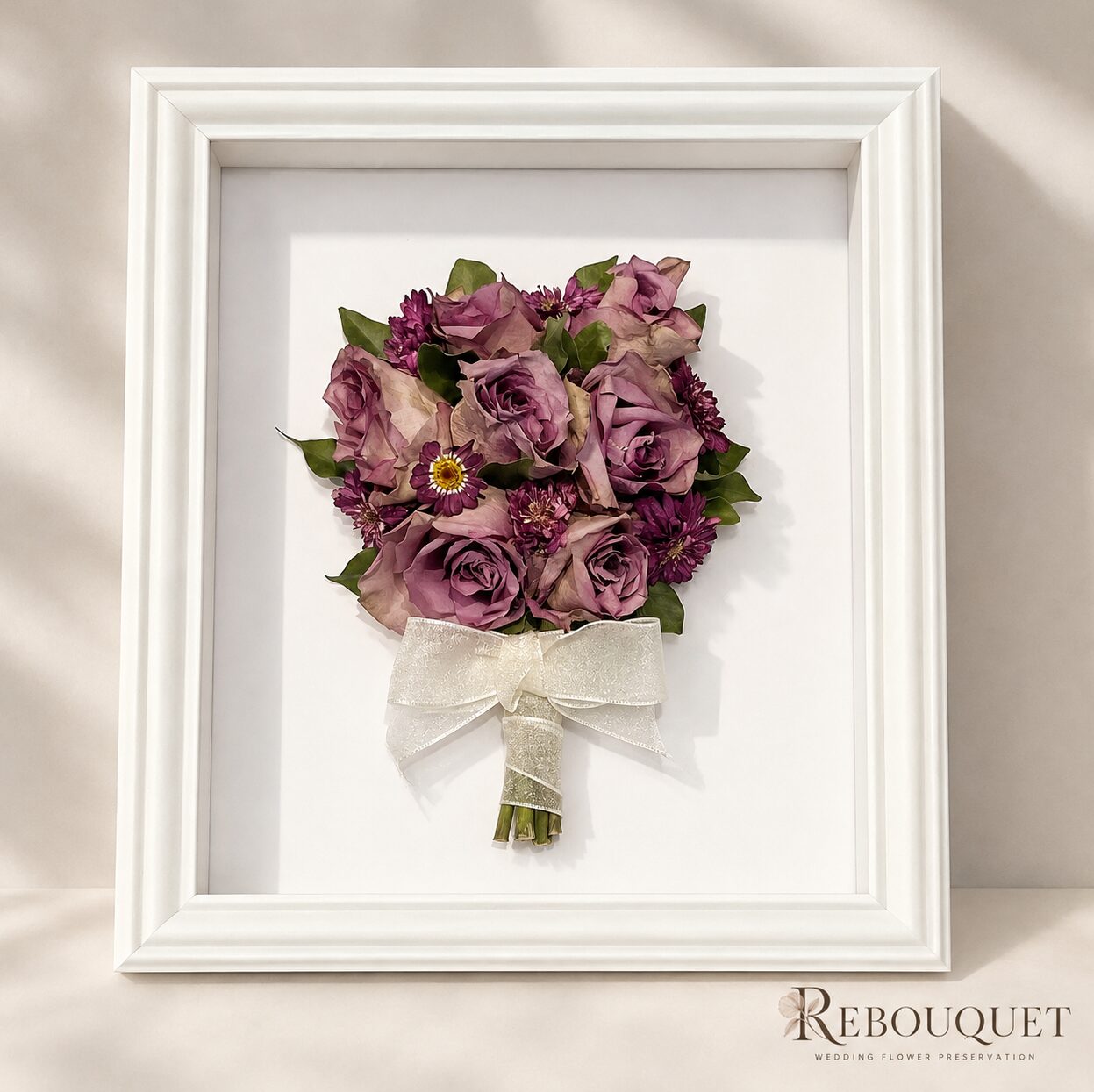 Preserved mauve rose and daisy bouquet in a white shadow box frame